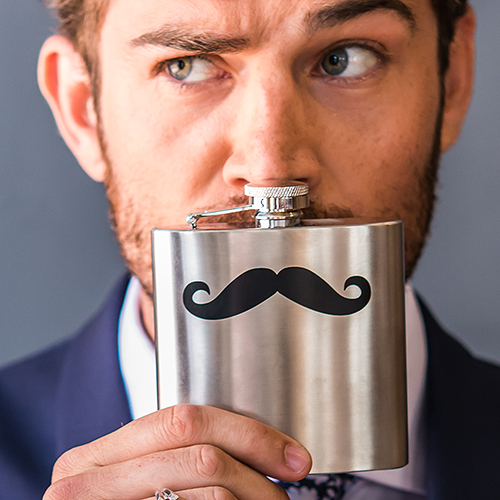 Groom holding a mustache flask