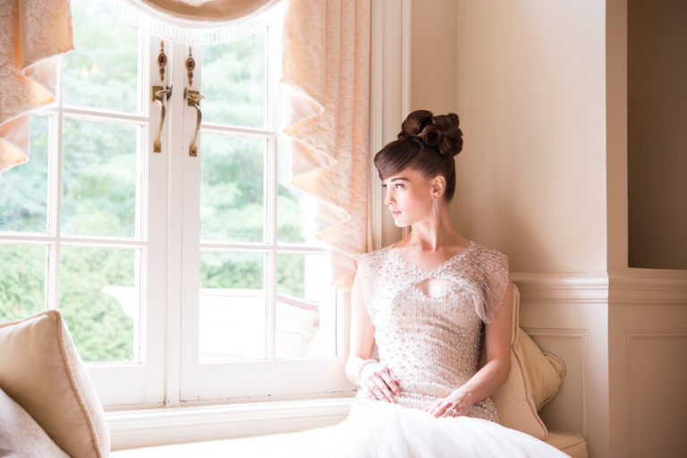 Bride Looking Out Of Window - Ivory Wedding Inspiration | Confetti.co.uk