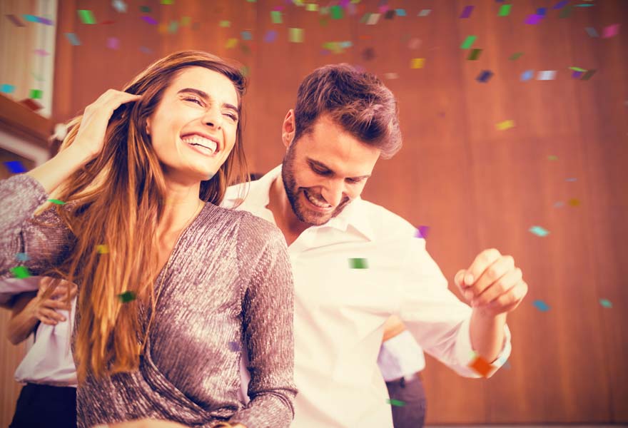 Engaged couple dancing at party