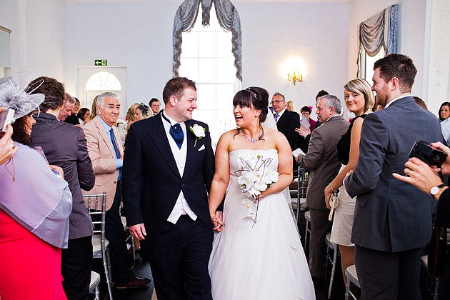 bride groom walking down aisle together holding hands