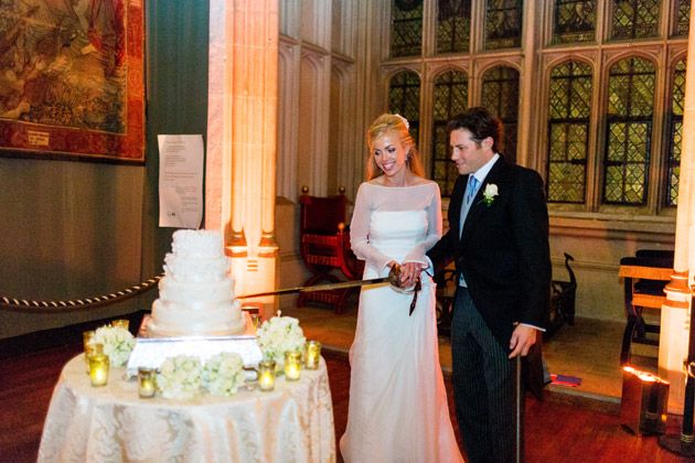 Bride and groom cutting the cake with a sword | Confetti.co.uk