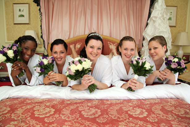 Bride with bridesmaids holding white and lavender bouquets