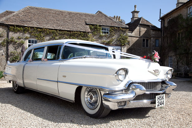 White Vintage Wedding Car with Flowers and White Ribbon