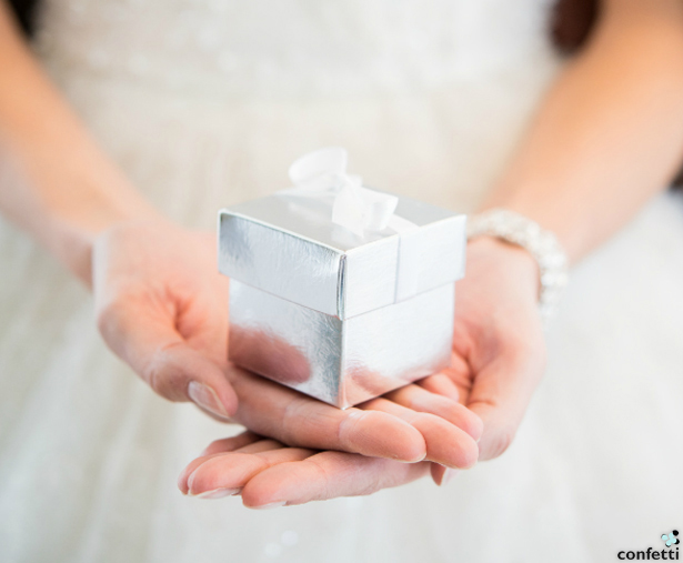 Woman Holding out a Christmas present | Confetti.co.uk