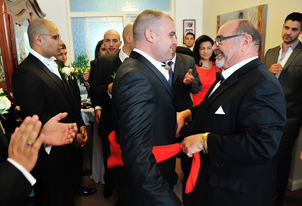 Grooms taking part in Greek wedding traditions