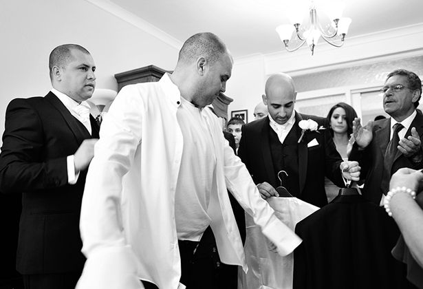 Grooms taking part in Greek wedding traditions