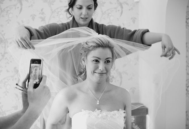 Bridesmaid helping the bride with her veil