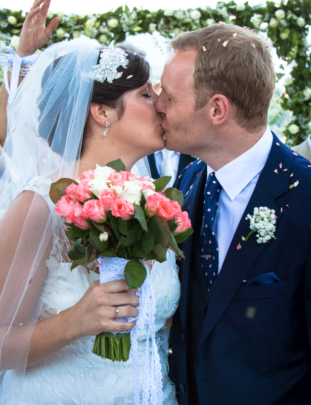 Guests throwing confetti on the newlyweds 