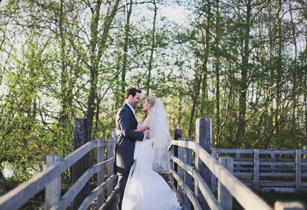 The bride and groom on a bridge by Sansom Photography 