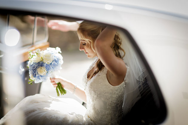 The bride in a silver vintage wedding car  