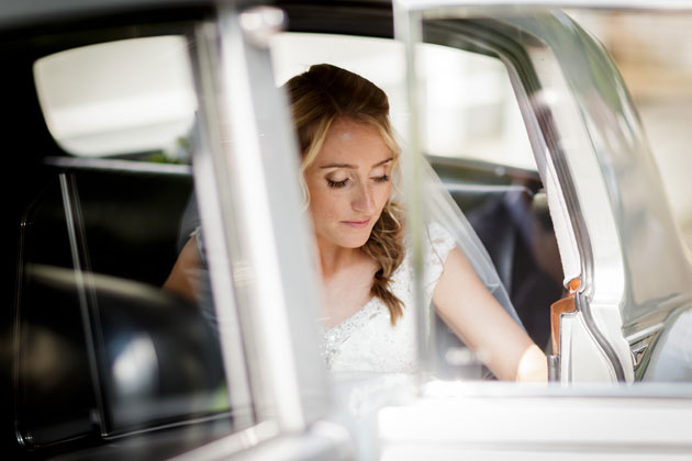 The bride in a silver vintage wedding car  