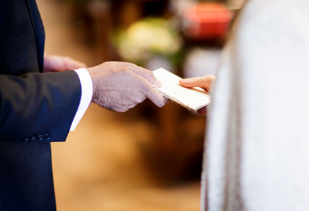 Order of service being passed to the reverend