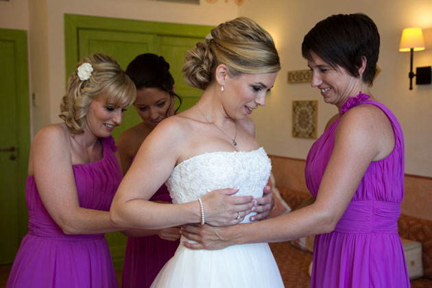 Bridesmaids helping the bride get ready 