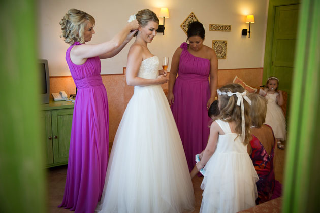 Bridesmiad adding a flower to the brides hair 