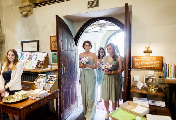 Bridesmaids in pale green dresses making their way to the ceremony 