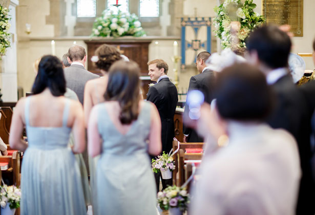 Bridesmaids in pale green dresses making their way to the ceremony 