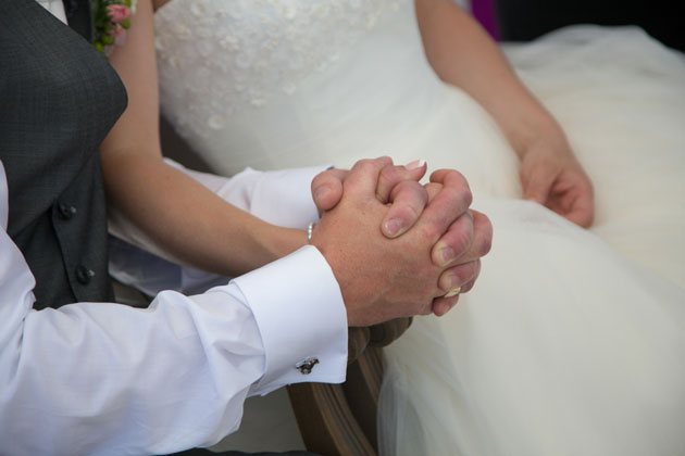 The bride and groom holding hands during the ceremony 