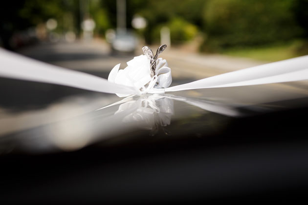 Silver Rolls Royce wedding car with white ribbon 