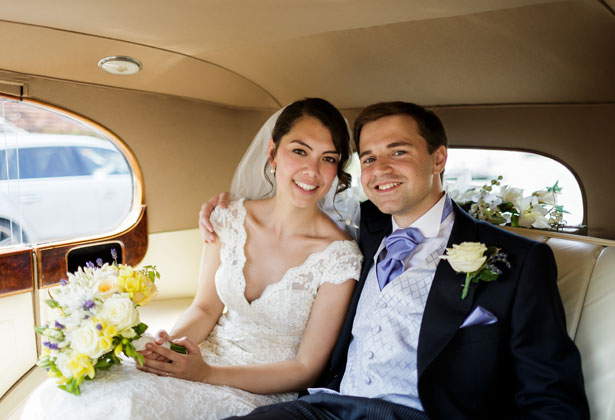 Bride and groom leaving the church in a vintage car   