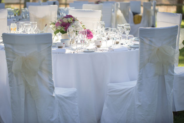 White reception decor and ivory chair bows