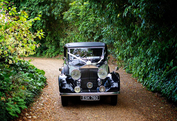 Bride arriving in a black vintage car 