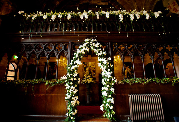 White indoor flower arrangement on leafy arch