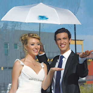 Bride and groom under umbrella