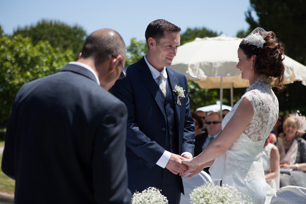 Bride and groom holding hands at the ceremony 