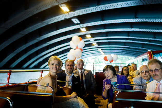 The newlyweds with their guests on the open top red bus     