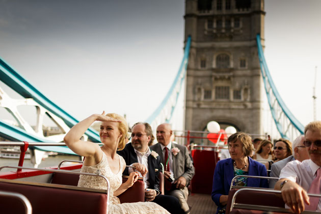 The newlyweds with their guests on the open top red bus on the London bridge