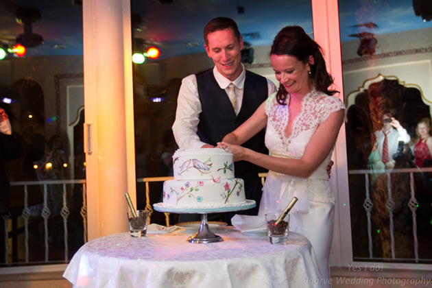 Happy couple cutting their painted wedding cake     