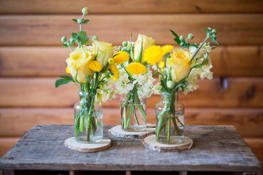 Glass Bottles and Flowers Rustic Decor | Confetti.co.uk