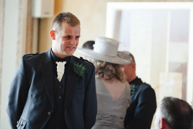 The groom in a grey kilt with a thistle button hole  