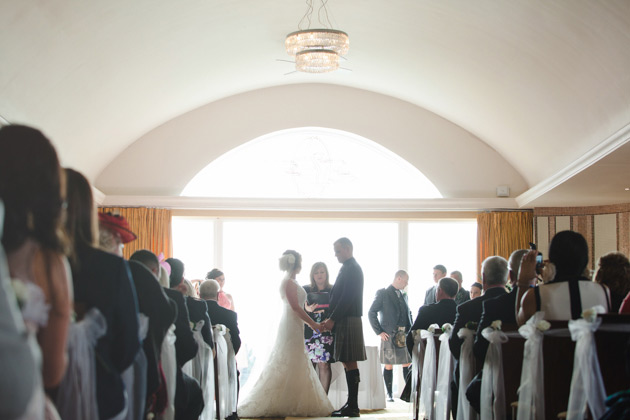 The bride and groom holding hands at the ceremony