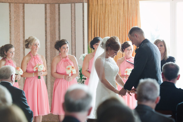 The bride and groom holding hands as the bridesmaids look on 