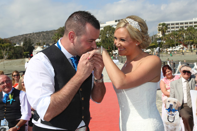 The groom kissing his brides hand  