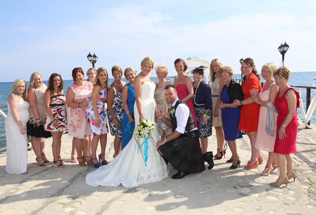 The happy couple with their family and friends on the pier