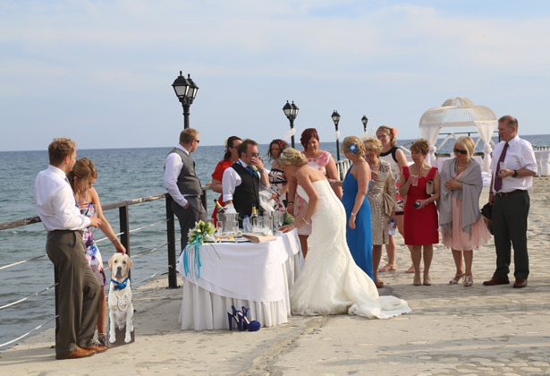 Wedding guests enjoying champagne on the pier  