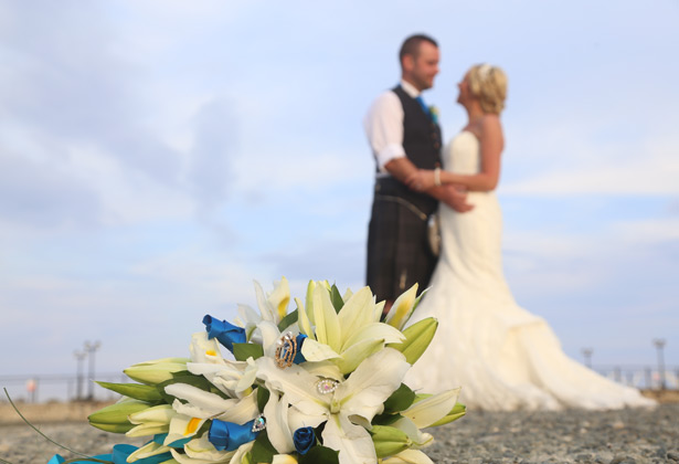 Brides lily bouquet with blue ribbons and brooches 