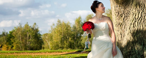 Bride with red rose bouquet by Bloom Bloom