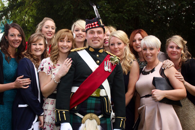 Groom in a military uniform with wedding guests