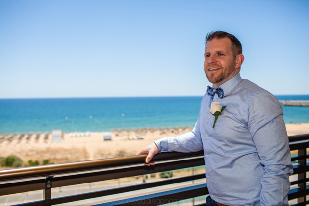 Groom in a blue shirt and blue checked bow tie 