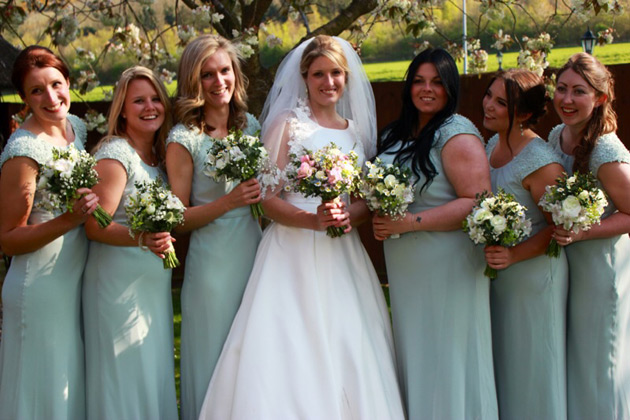 Brides with her bridesmaids in pale sage green dresses  