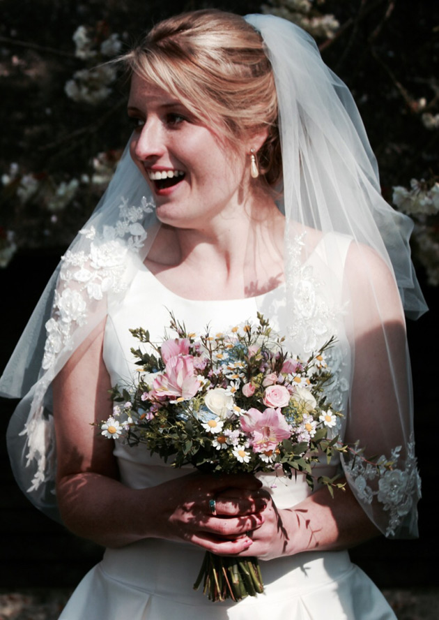 Bride in her white lace gown and vintage bouquet