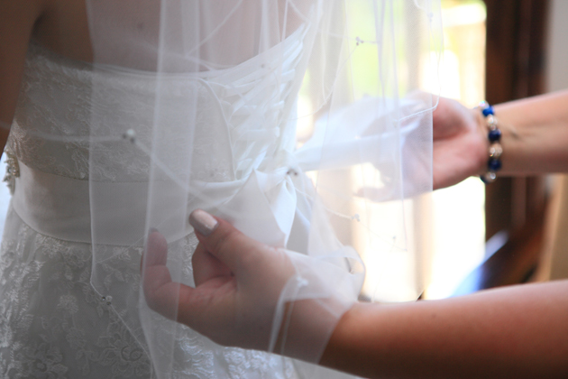 Tying the belt of the brides Maggie Sottero dress