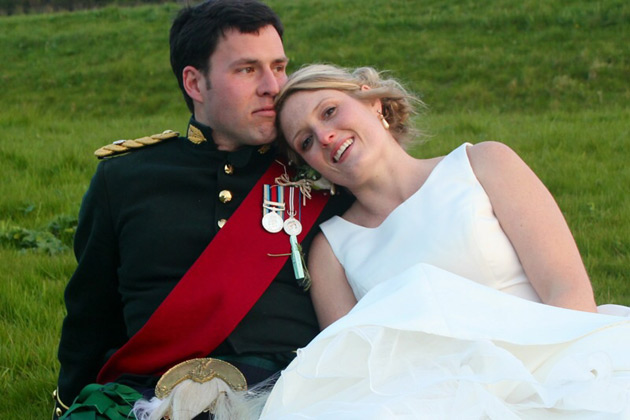 The bride and groom sitting on the grass