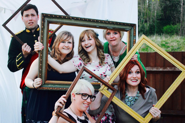 Groom and the wedding guests holding photo frames 