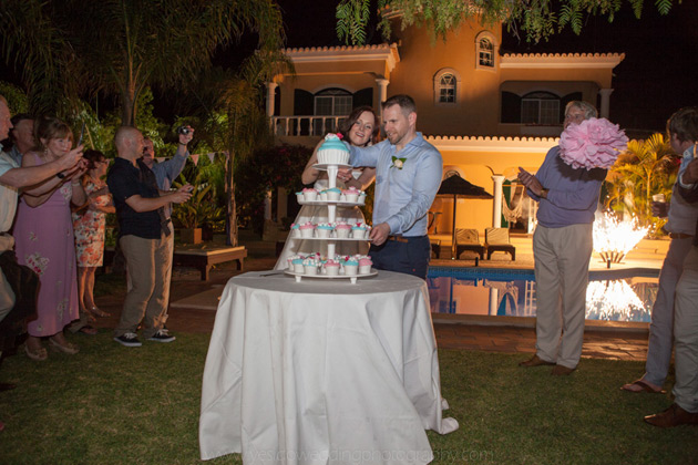 Bride and groom cutting the giant wedding cupcake 