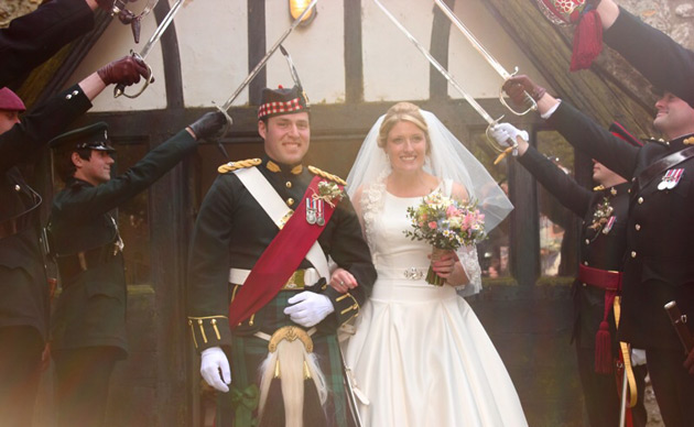 The newlyweds walking through an arch of swords