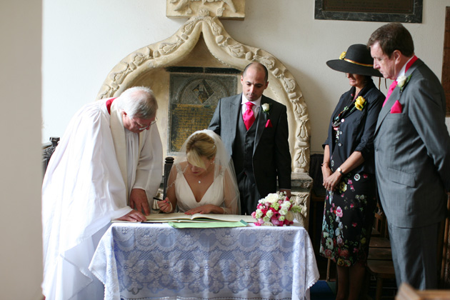 The newlyweds signing the register| Confetti.co.uk